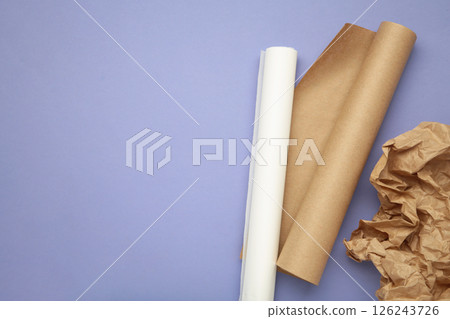 Rolls of white and brown baking paper on purple background 126243726
