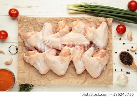 Raw chicken wings with ingredients for cooking on wooden cutting board on white Raw chicken wings with ingredients for cooking on wooden cutting board on white 126243736
