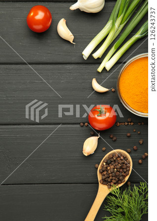 Kitchen cooking background: cherry tomatoes, onions, spices and herbs on black wooden background. Kitchen cooking background: cherry tomatoes, onions, spices and herbs on black wooden background. 126243737