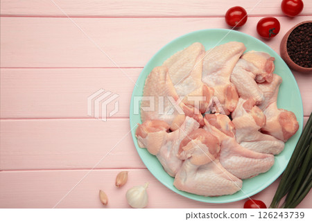 Raw chicken wings with ingredients for cooking on mint plate on pink wooden background 126243739