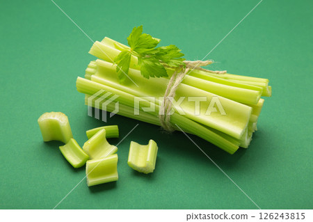 Fresh green cut celery on green background Fresh green cut celery on green background 126243815
