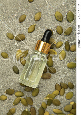 Pumpkin seed oil on grey concrete background. Top view Pumpkin seed oil on grey concrete background. Top view 126243826