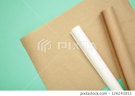 Rolls of white and brown baking paper on mint background 126243851