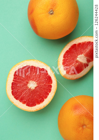 Fresh raw grapefruit on mint background. Vertical photo Fresh raw grapefruit on mint background. Vertical photo 126244428