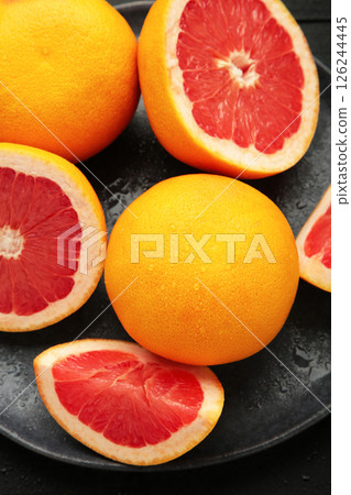 Grapefruit and water drops on dark background. Vertical photo Grapefruit and water drops on dark background. Vertical photo 126244445