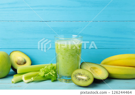 Green smoothie in glass made from kiwi, celery, apples, banana. Detox concept, healthy food, diet, vegetarian. Smoothie on blue 126244464