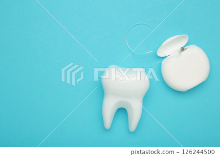 White healthy tooth with dental floss. Oral dental care products, hygiene cleaning personal use lifestyle concept 126244500