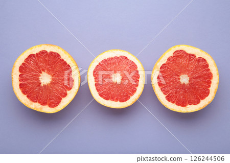 Half of fresh grapefruit on a purple background Half of fresh grapefruit on a purple background 126244506