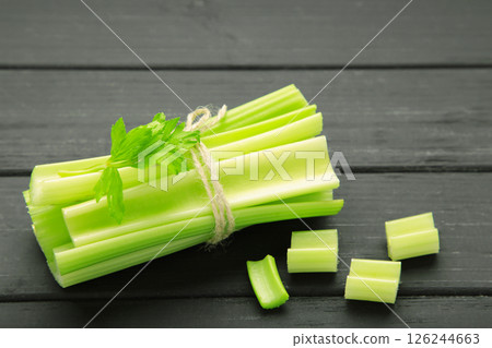Fresh green cut celery on black wooden background 126244663