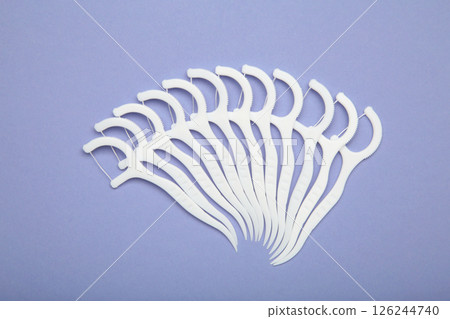 Floss toothpick on purple background. Dental hygiene concept. Floss toothpick on purple background. Dental hygiene concept. 126244740