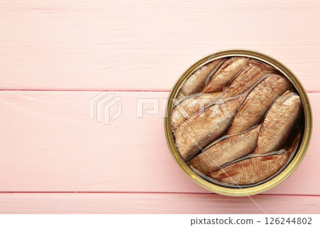 Opened can with sprats in oil on a wooden pink background 126244802