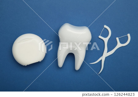 White healthy tooth with dental floss. Oral dental care products, hygiene cleaning personal use lifestyle concept White healthy tooth with dental floss. Oral dental care products, hygiene cleaning personal use lifestyle concept 126244823