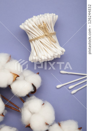 White cotton stricks on purple textured background. Eco friendly. Hygienic cotton swabs for ears. Top view 126244832