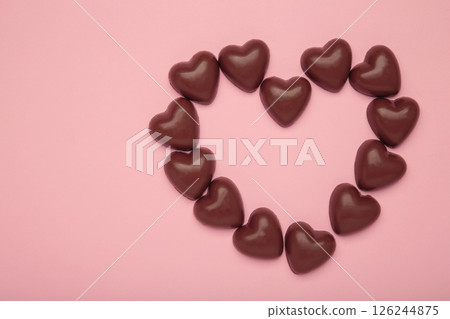 Red chocolate sweets as heart on pink background. Valentine's day concept. Red chocolate sweets as heart on pink background. Valentine's day concept. 126244875