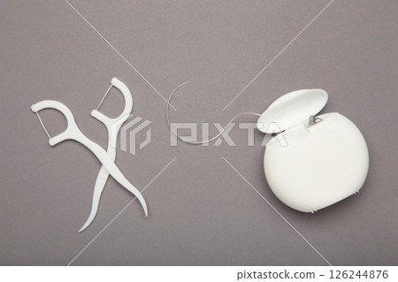 Different dental floss on grey background. Oral dental care products, hygiene cleaning personal use lifestyle concept Different dental floss on grey background. Oral dental care products, hygiene cleaning personal use lifestyle concept 126244876