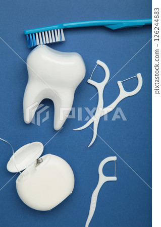 White healthy tooth with dental floss on blue. Oral dental care products, hygiene cleaning personal use lifestyle concept 126244883