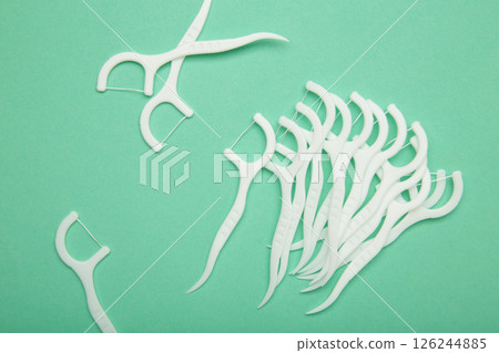 Floss toothpick on mint background. Dental hygiene concept. 126244885