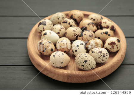 Quail eggs in wooden plate on black wooden background 126244899