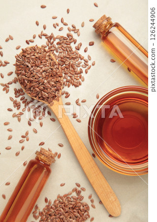 Flaxseeds with flaxseed oil in bowl on light background. Vertical photo 126244906