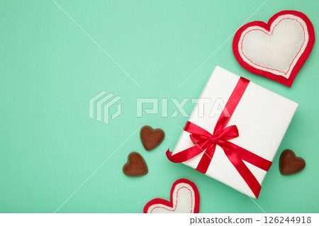 Valentine's day greeting card with gift, hearts chocolate sweets on mint background. 126244918
