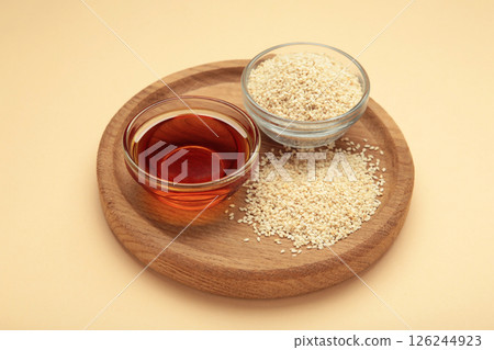 Sesame seeds and sesame oil on beige background Sesame seeds and sesame oil on beige background 126244923