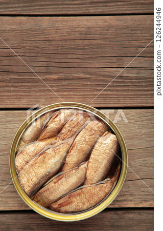 Opened can with sprats in oil on grey wooden background 126244946