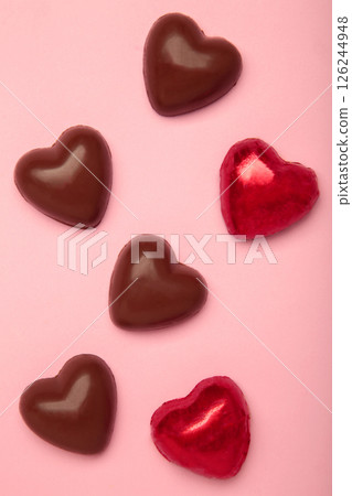 Red chocolate sweets as heart on pink background. Valentine's day concept. Red chocolate sweets as heart on pink background. Valentine's day concept. 126244948