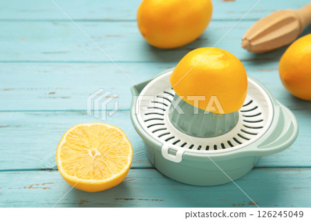 Squeezer and lemons on blue wooden background 126245049