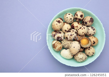 Quail eggs in bowl on purple background 126245051