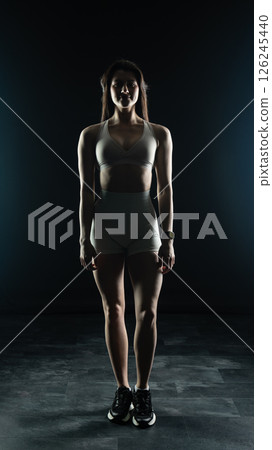 Young beautiful woman with athletic body on dark background. Fitness girl 126245440