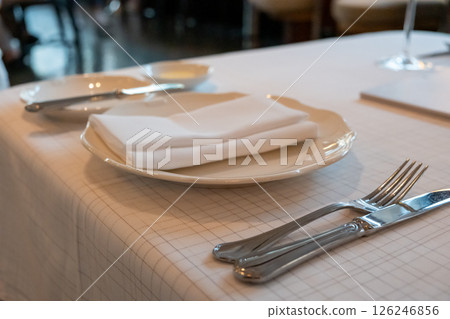 A set of spoon, fork, knife and plate prepared on the table, in the restaurant 126246856