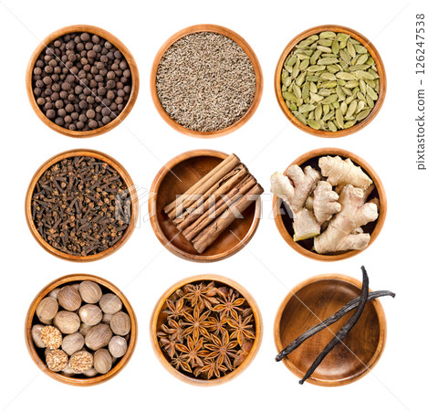 Christmas spices and scents of winter holidays in wooden bowls. Allspice, anise, and cardamom in the 1st row, cloves, cinnamon, and ginger in 2nd, and nutmeg, star anise, and vanilla in the 3rd row. 126247538