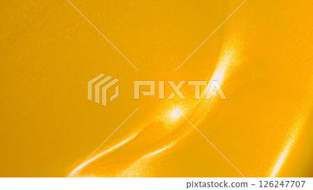 a highly reflective, metallic yellow surface, likely a close-up of automotive paint or a coated object with a pearlescent or candy finish a highly reflective, metallic yellow surface, likely a close-up of automotive paint or a coated object with a pearlescent or candy finish 126247707