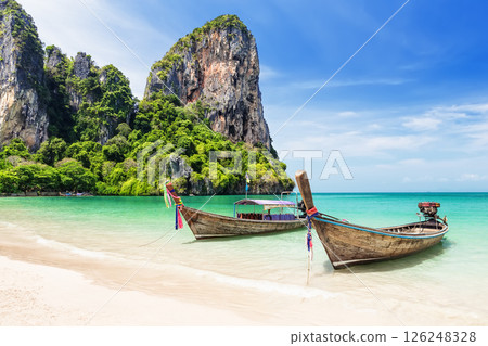 Two thai traditional wooden longtail boats and beautiful sand Railay Beach in Krabi province. Ao Nang, Thailand. Two thai traditional wooden longtail boats and beautiful sand Railay Beach in Krabi province. Ao Nang, Thailand. 126248328