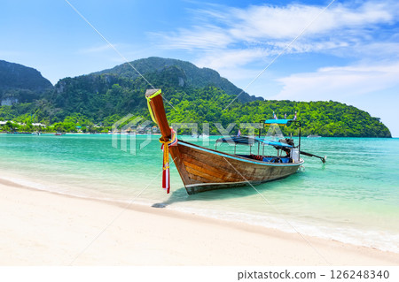 Thai traditional wooden longtail boat and beautiful sand beach in Phi Phi islands, Thailand. 126248340