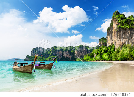 Thai traditional wooden longtail boat on tropical beach with limestone rock, Railay Beach in Krabi province., Thailand. 126248355