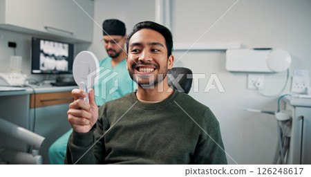 Happy man, mirror and dentist with teeth for dental care, hygiene or oral treatment at orthodontist. Male person, patient or smile with surgeon for tooth removal, veneers or extraction at clinic 126248617