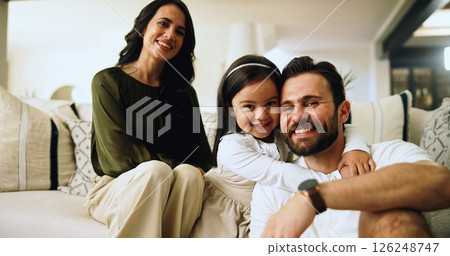 Portrait, happy family and parents with girl, hug and living room sofa with love and relax in home. Mom, dad and child on couch with support, man and woman with daughter for weekend break or trust 126248747
