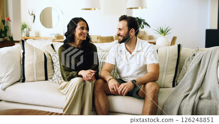 Couple, happy and relax on sofa in home with security, support and relationship connection. Love, people and smile in living room with conversation, marriage commitment and bonding together with care 126248851