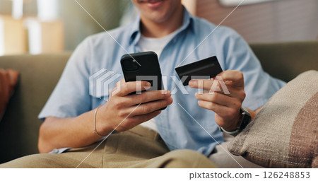 Man, hands and phone with credit card for online shopping, ecommerce and payment portal in home. Customer, tech and debit transaction on sofa for cart checkout, banking app and virtual purchase Man, hands and phone with credit card for online shopping, ecommerce and payment portal in home. Customer, tech and debit transaction on sofa for cart checkout, banking app and virtual purchase 126248853