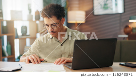 Man, laptop and documents in home for budget, personal finances and monthly expenses for startup. Entrepreneur, tech and paperwork in lounge for small business management, invoice payment or taxes Man, laptop and documents in home for budget, personal finances and monthly expenses for startup. Entrepreneur, tech and paperwork in lounge for small business management, invoice payment or taxes 126248871