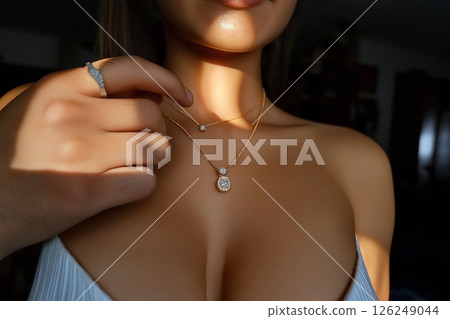 A close-up view of an elegant diamond necklace on a woman's neck, surrounded by a sophisticated atmosphere, emphasizing luxury, fashion, and exquisite jewelry at a glamorous evening setting. 126249044