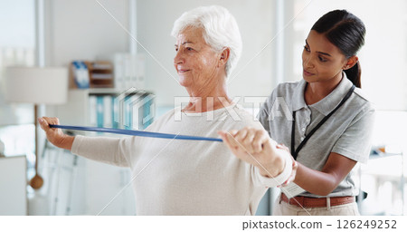 Senior woman, physiotherapist and resistance band with stretching, smile and healthcare services for recovery. People, happy and exercise with equipment, help and injury for rehabilitation at clinic 126249252