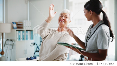 Senior woman, physiotherapist and happy with high five, support and results for recovery at clinic. People, elderly patient and doctor with tablet for report, progress and rehabilitation for injury 126249362