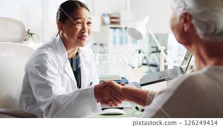 Doctor, senior woman and happy with handshake at clinic for introduction, thanks or healthcare service. People, elderly patient and shaking hands for hello, smile or welcome to consulting at hospital Doctor, senior woman and happy with handshake at clinic for introduction, thanks or healthcare service. People, elderly patient and shaking hands for hello, smile or welcome to consulting at hospital 126249414