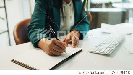 Business person, hands and writing with book at office desk for reminder, schedule planning or agenda. Closeup, employee or planner taking notes with ideas in notebook or diary for tasks at workplace 126249448