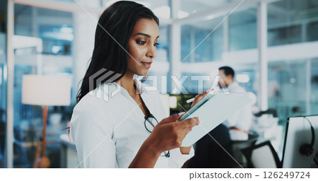 Woman, developer and reading on tablet in office for IT, coding software and server update. Female person, digital or testing app of online programming, website application and troubleshooting system 126249724