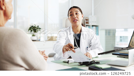 Elderly woman, doctor and consultation for prescription instruction, referral letter and healthcare report. Medical professional, appointment and talk to patient with paper for diagnosis in hospital 126249725