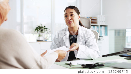 Senior patient, doctor and prescription note with pharma letter or health report. Medical professional, consulting and old woman with dosage instruction, medicine script or treatment plan in clinic 126249745