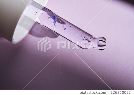 Pipette with serum on purple background with sunlight. Pipette with serum on purple background with sunlight. 126250052